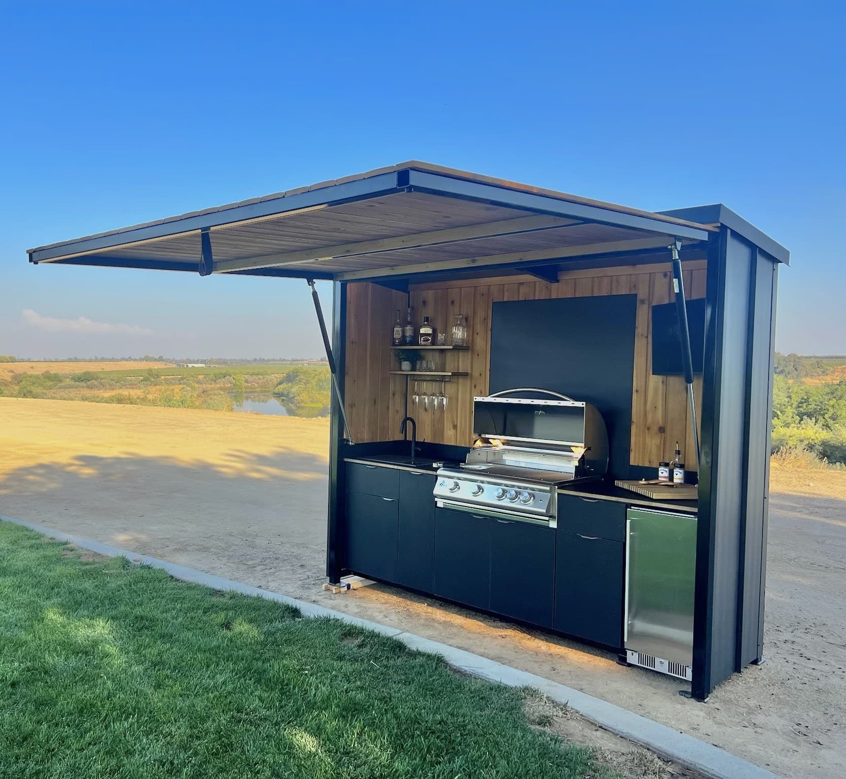 Enclosed outdoor kitchen pod installed on a patio with the awning raised